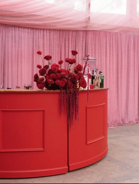 Custom red painted bar styled with floral arrangement