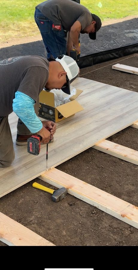 Crew members installing custom wood-look flooring panels