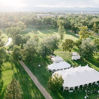 Aerial view of white tents set up on a green lawn